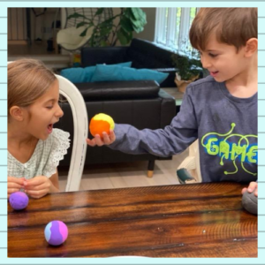 A boy treating a ball as an apple and offering it to a girl. An example of turning everyday objects into new adventures.